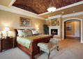 Custom master bedroom with raised ceiling, fireplace and archway